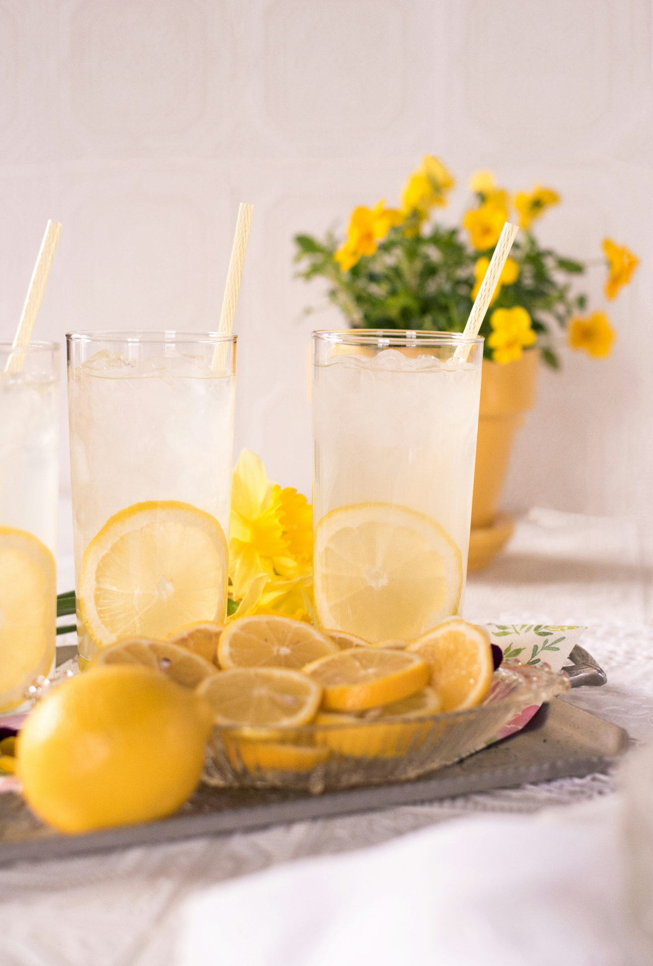 Lemonade glasses with sliced lemons and flowers